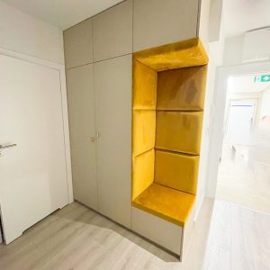 Garderobe-im-Flur-mit-gelben-gepolsterten-Paneelen